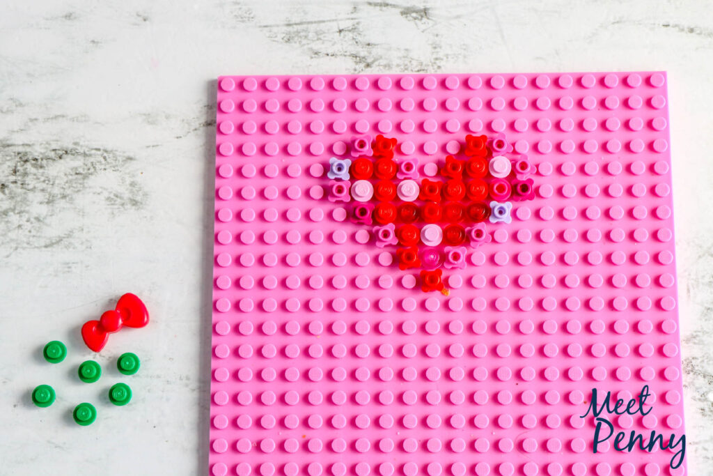 The LEGO Base Plate Valentine tutorial is an easy LEGO build inspiring love to bloom. The activity does not require any special bricks as you can construct the Valentine's Day Card using the small LEGOs you have on a base plate of any color.